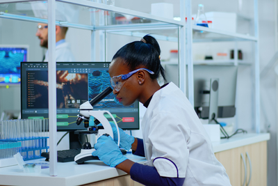Nursing student looking through microscope in a lab